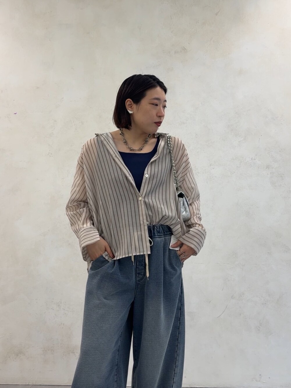 ブルー系のその他パンツ、ホワイト系のシャツ/ブラウス、シルバー系のショルダーバッグを着用したレディースの夏コーディネートの9枚目の写真