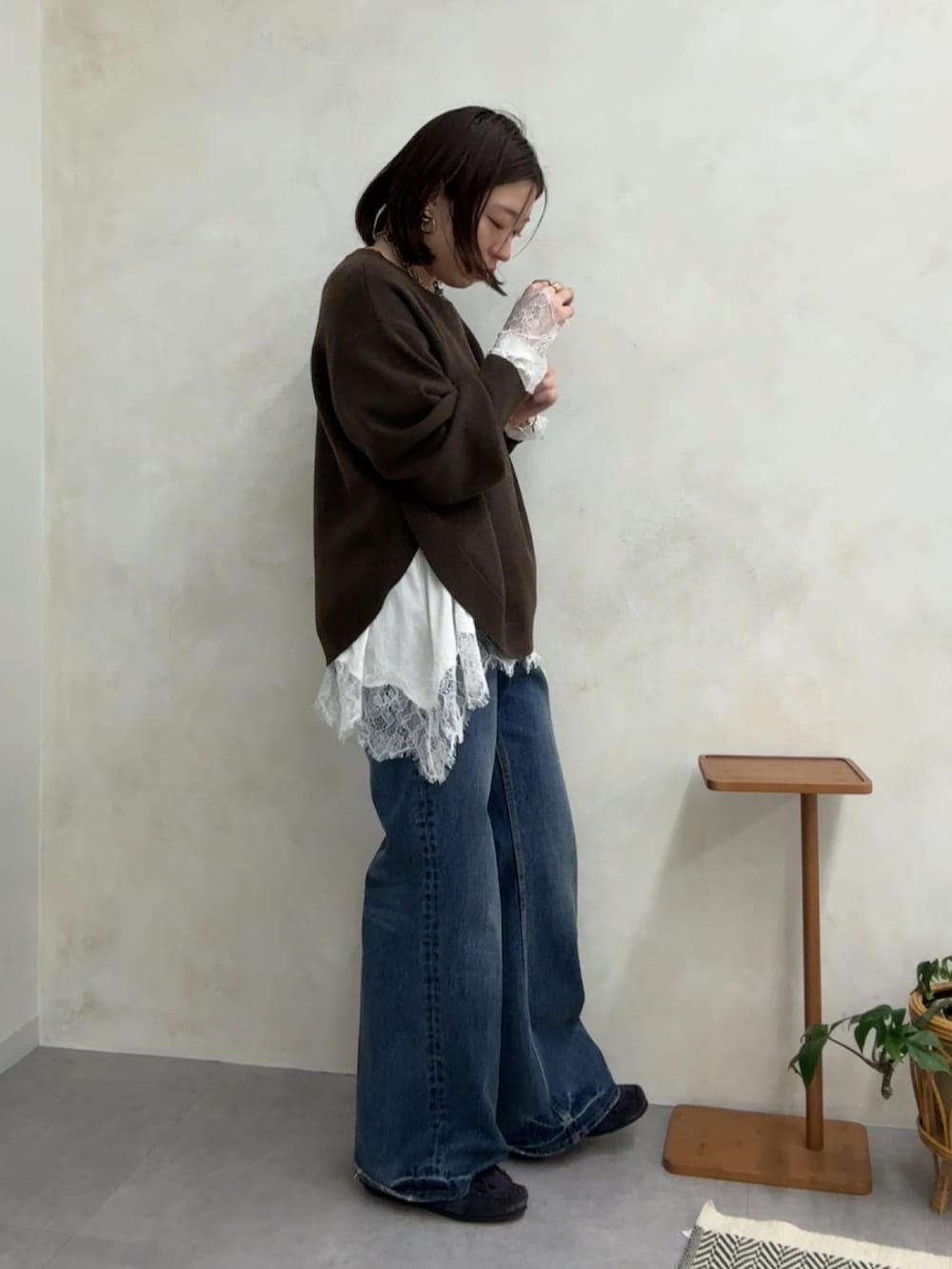 ブラウン系のニット/セーター、ホワイト系のTシャツ/カットソー、ブルー系のデニムパンツを着用したレディースの冬コーディネートの3枚目の写真