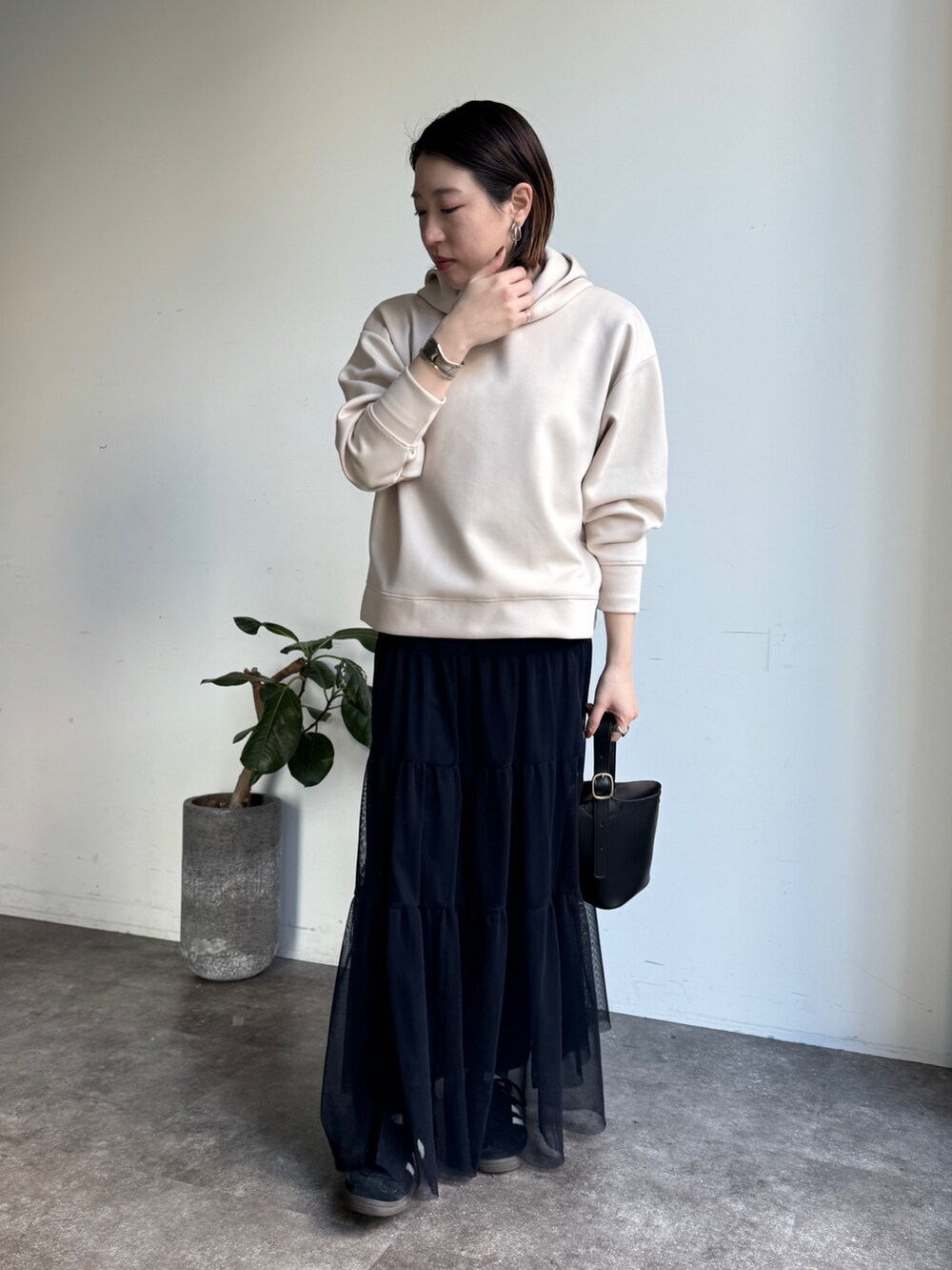 ホワイト系のセットアップ、ブルー系のスカートを着用したレディースの冬コーディネートの4枚目の写真