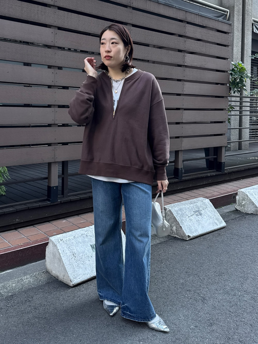 ブラウン系のスウェット、グレー系のシャツ/ブラウス、ブルー系のデニムパンツを着用したレディースの冬コーディネートの6枚目の写真