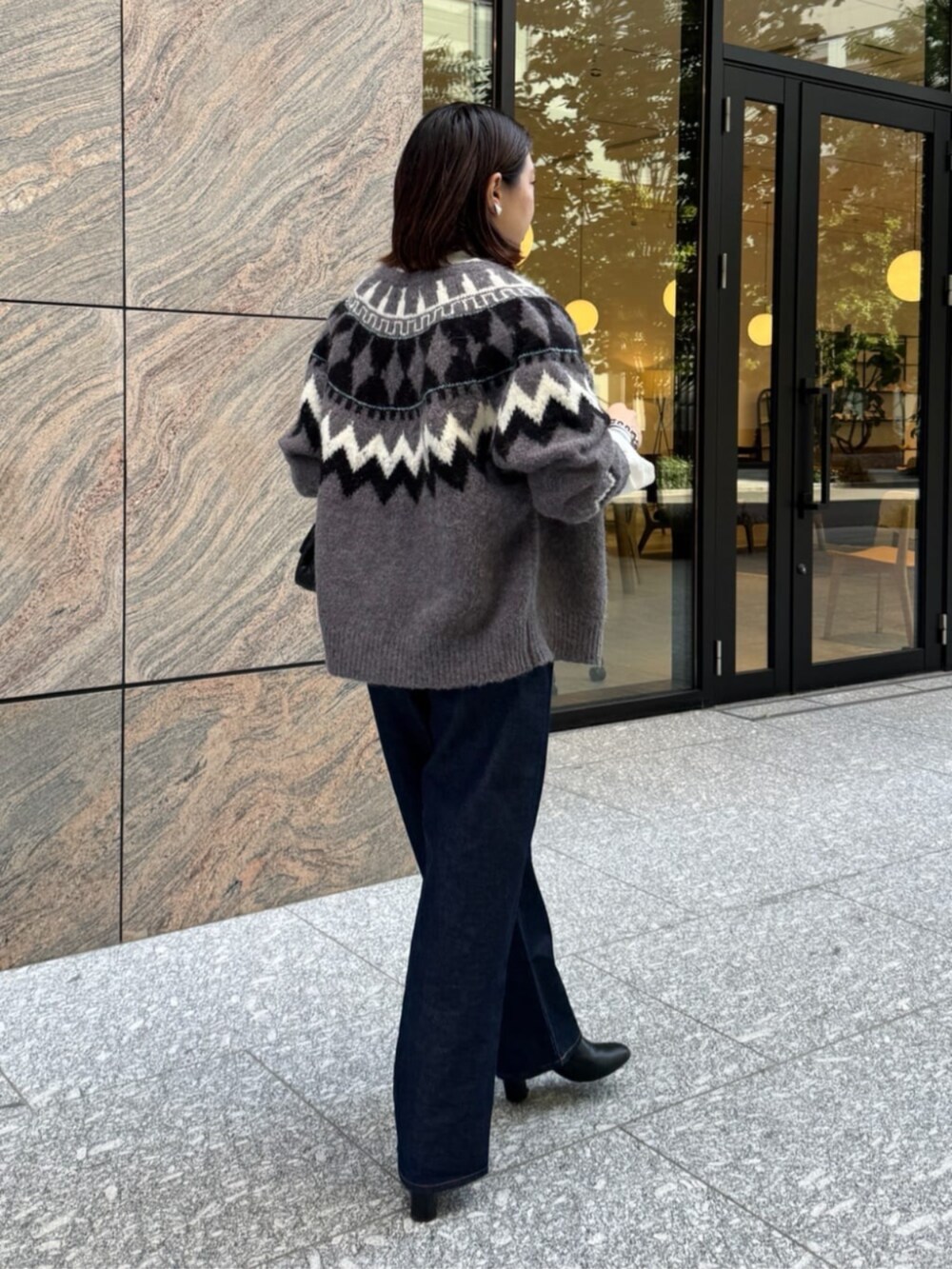 ブラック系のショルダーバッグ、ブルー系のデニムパンツ、ホワイト系のシャツ/ブラウスを着用したレディースの秋コーディネートの5枚目の写真