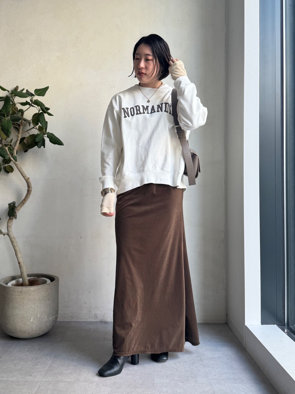 ベージュ系のその他アウター、ブラウン系のスカート、ホワイト系のTシャツ/カットソーを着用したレディースの冬コーディネートの9枚目の写真