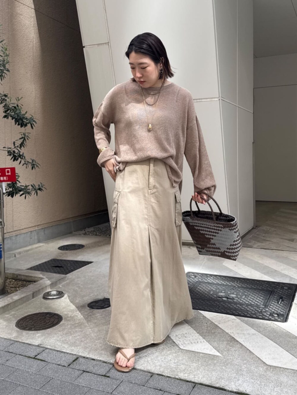 ベージュ系のスカート、ゴールド系のネックレスを着用したレディースの春コーディネートの4枚目の写真