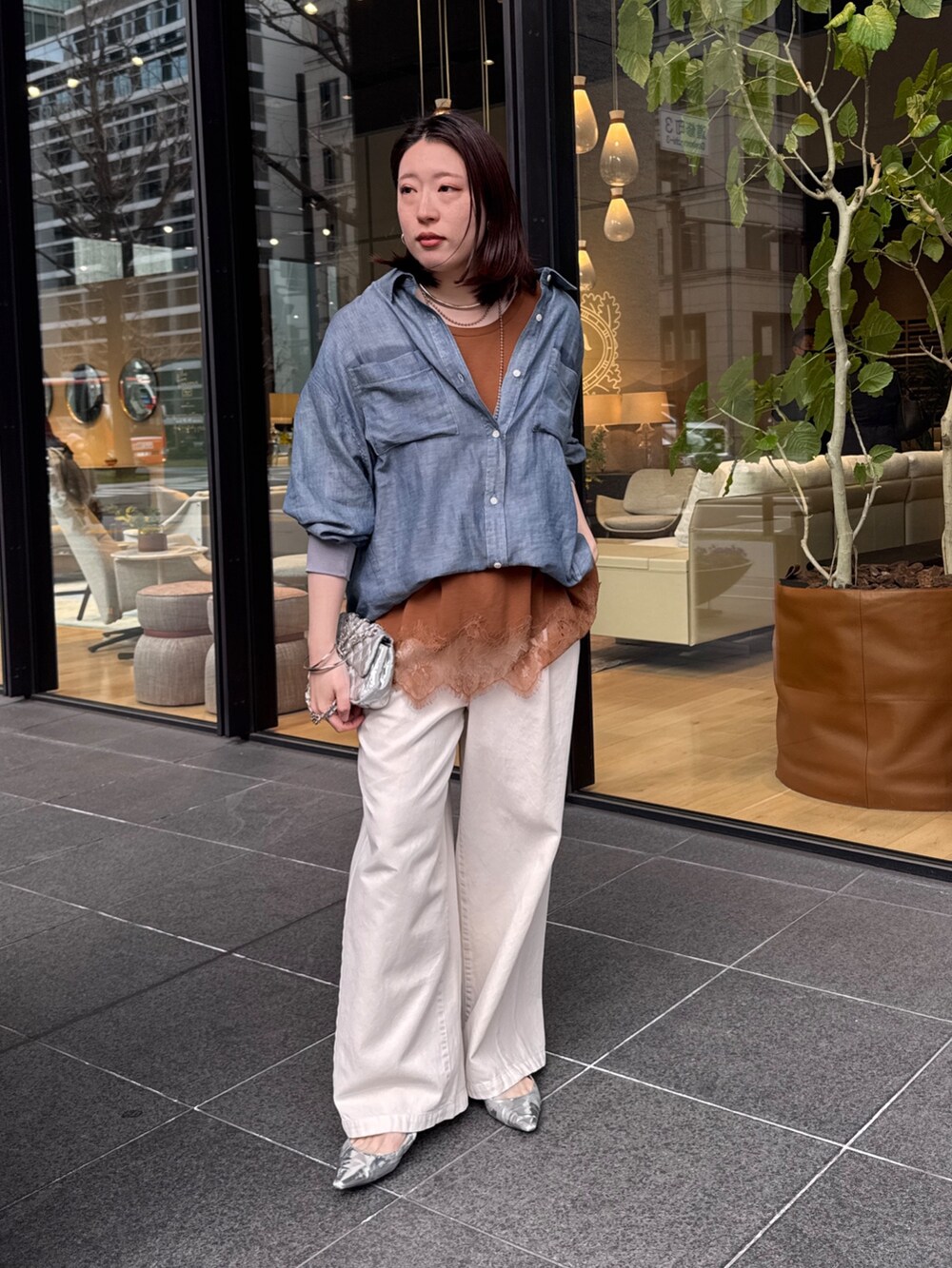 ブルー系のシャツ/ブラウス、ブラウン系のTシャツ/カットソー、ベージュ系のデニムパンツを着用したレディースの春コーディネートの6枚目の写真