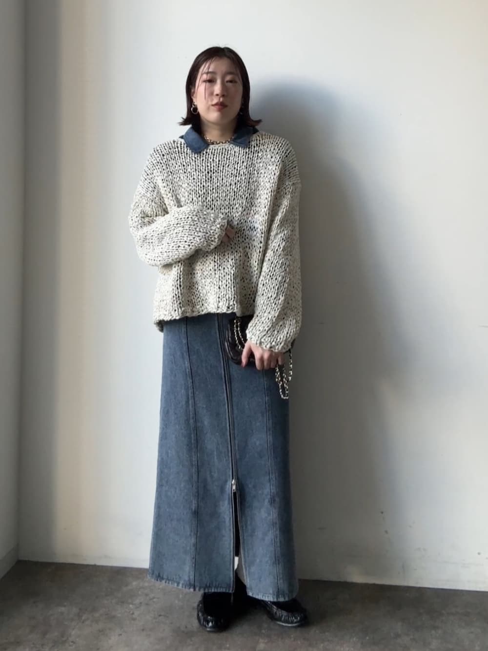 グレー系のニット/セーター、ブルー系のスカート、ブルー系のシャツ/ブラウスを着用したレディースの冬コーディネートの5枚目の写真