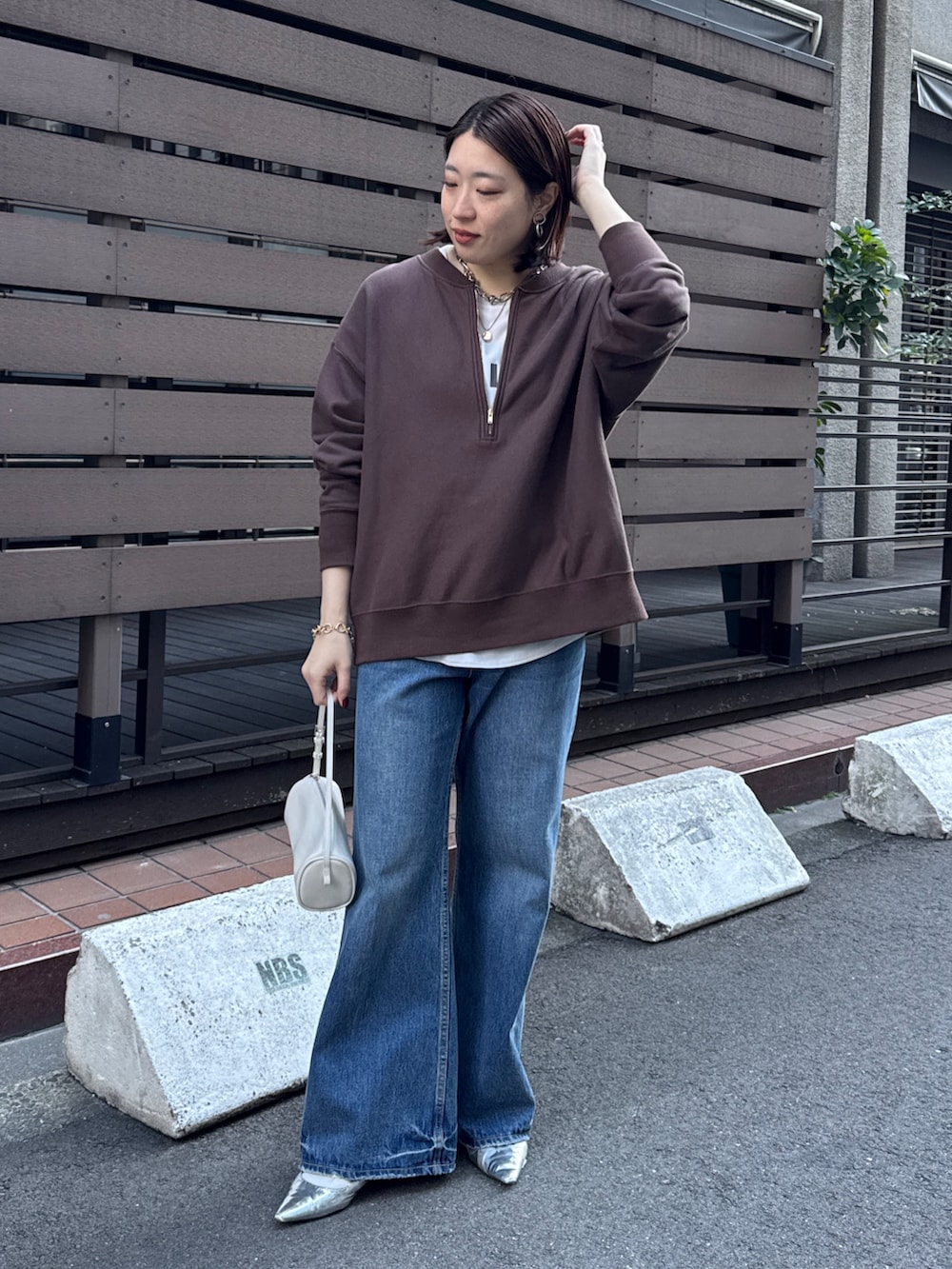 ブラウン系のスウェット、グレー系のシャツ/ブラウス、ブルー系のデニムパンツを着用したレディースの冬コーディネートの5枚目の写真