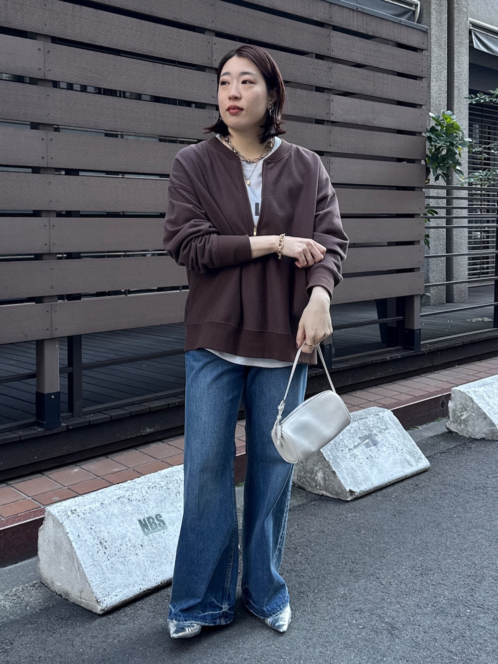 ブラウン系のスウェット、グレー系のシャツ/ブラウス、ブルー系のデニムパンツを着用したレディースの冬コーディネートの4枚目の写真