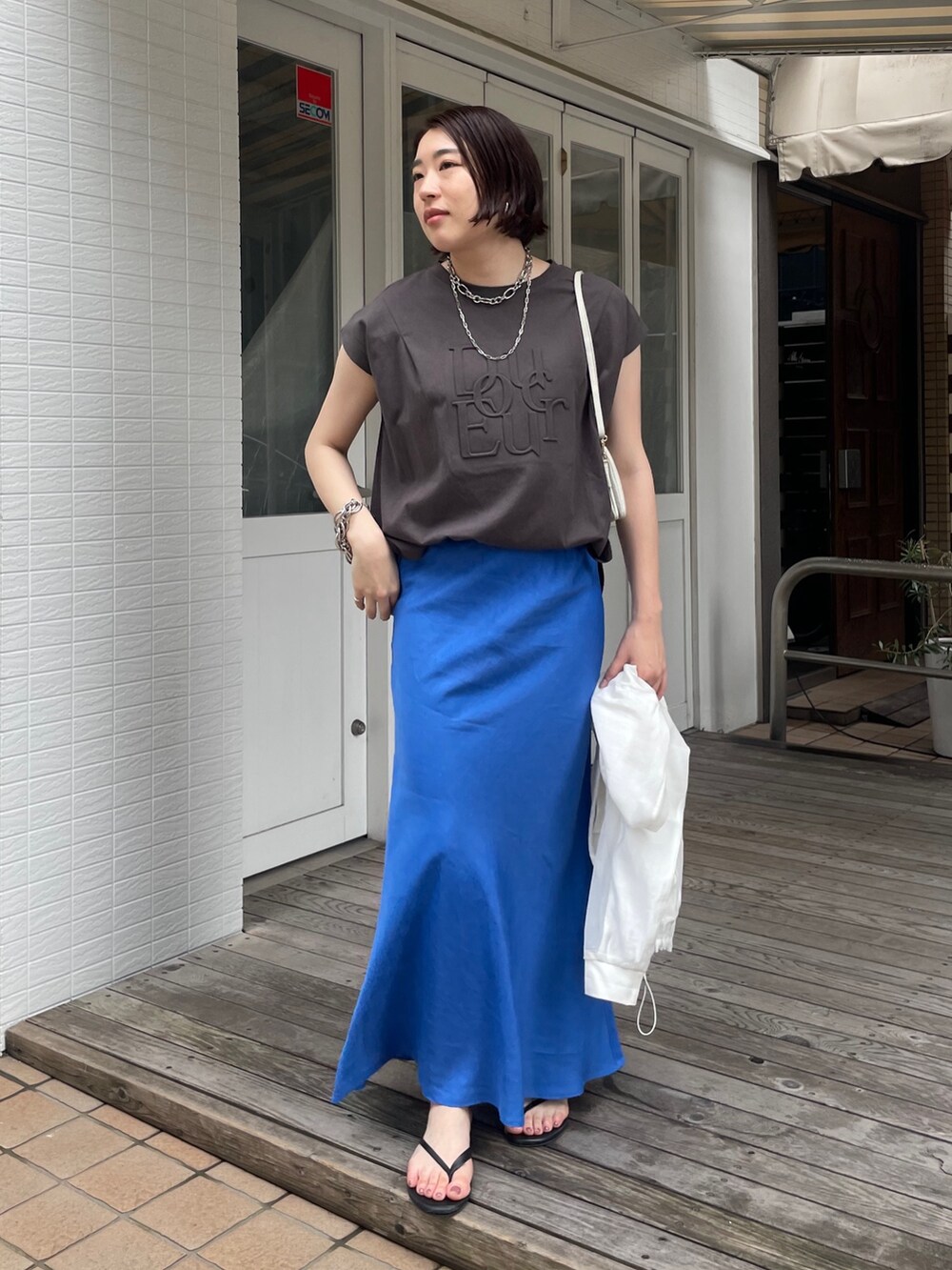 ブルー系のスカート、グレー系のTシャツ/カットソー、ホワイト系のブルゾンを着用したレディースの春コーディネートの8枚目の写真