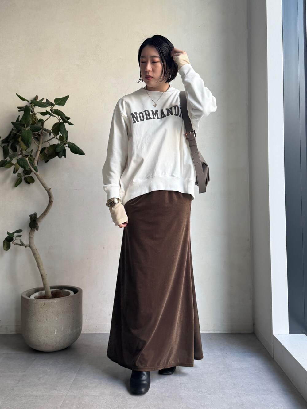 ベージュ系のその他アウター、ブラウン系のスカート、ホワイト系のTシャツ/カットソーを着用したレディースの冬コーディネートの5枚目の写真