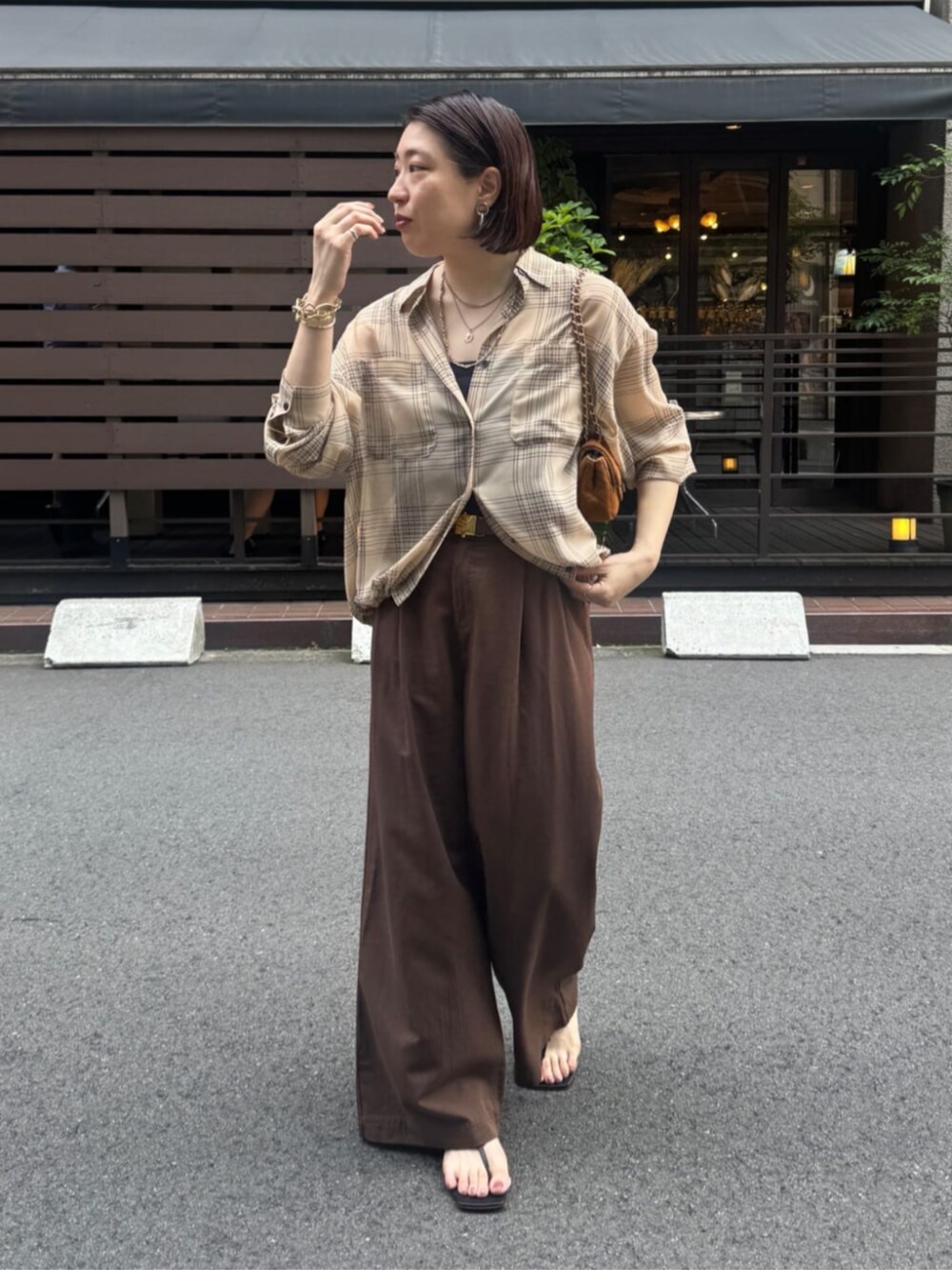 イエロー系のショルダーバッグ、ベージュ系のシャツ/ブラウス、ベージュ系のその他パンツを着用したレディースの夏コーディネートの8枚目の写真