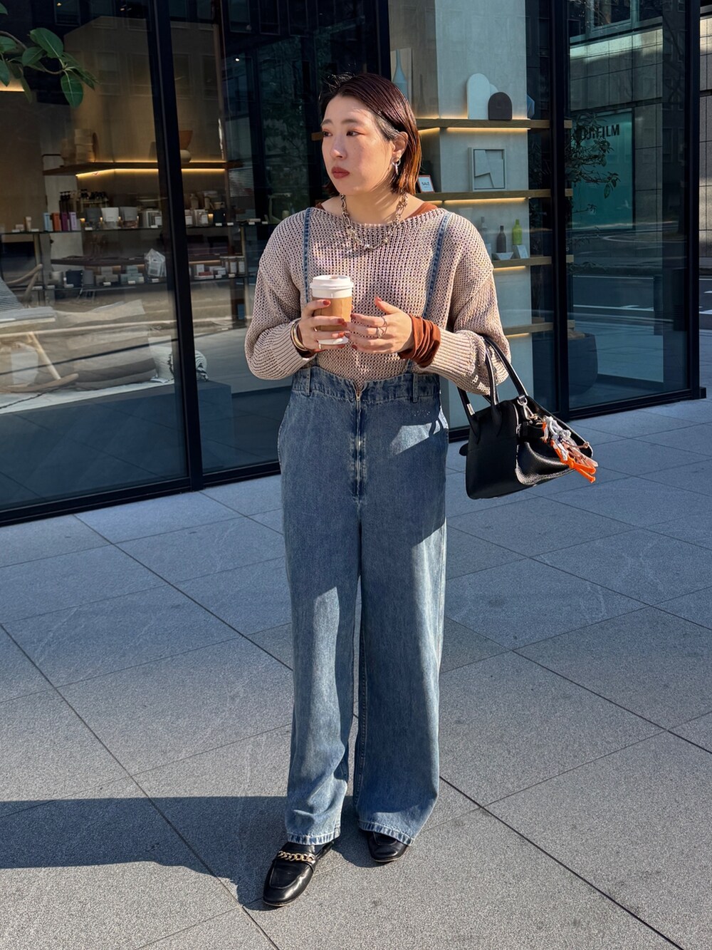 ベージュ系のニット/セーター、ブルー系のデニムパンツ、ブラウン系のTシャツ/カットソーを着用したレディースの冬コーディネートの2枚目の写真