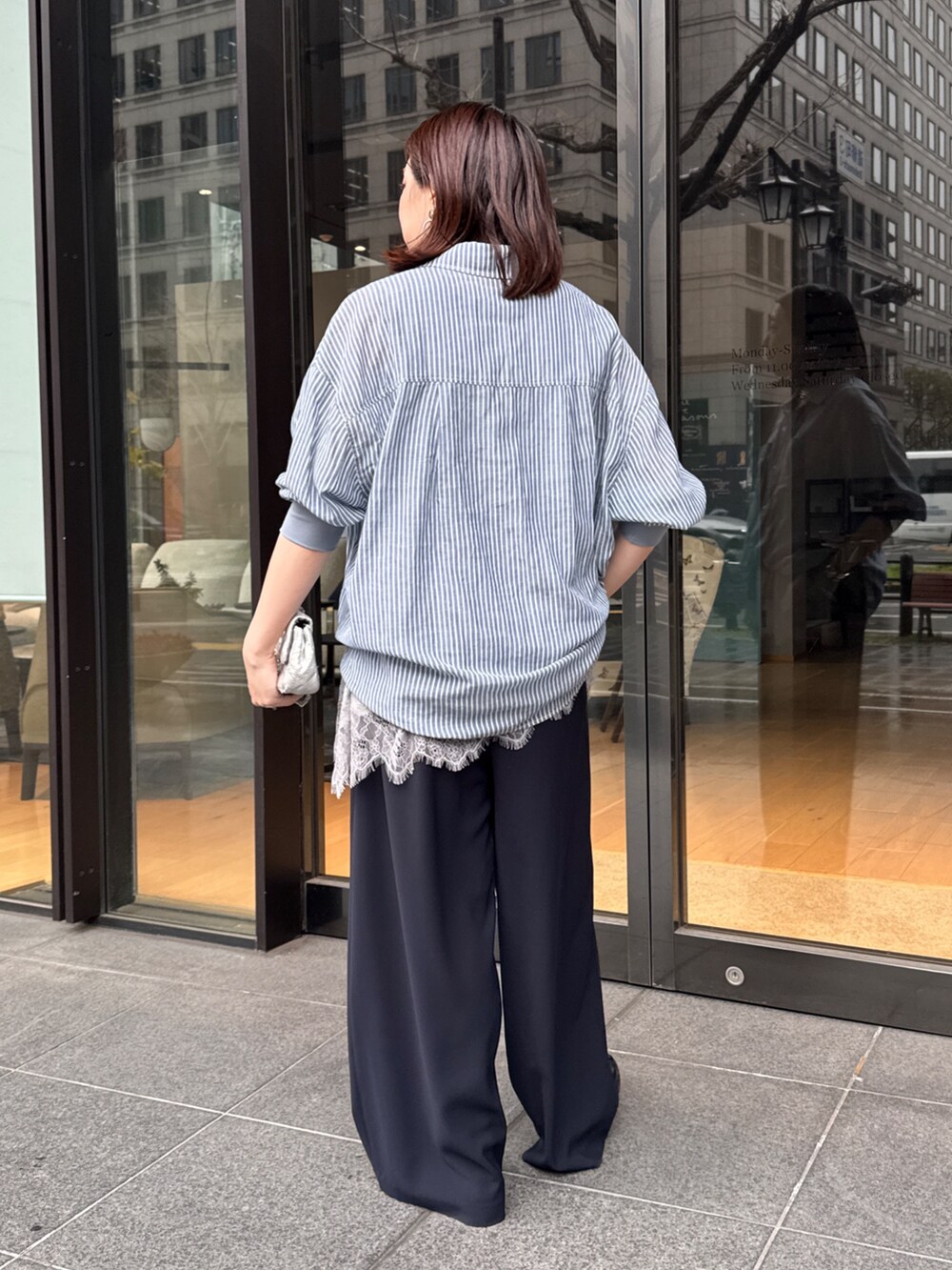 グレー系のTシャツ/カットソー、ブルー系のシャツ/ブラウス、ブルー系のスラックスを着用したレディースの春コーディネートの5枚目の写真