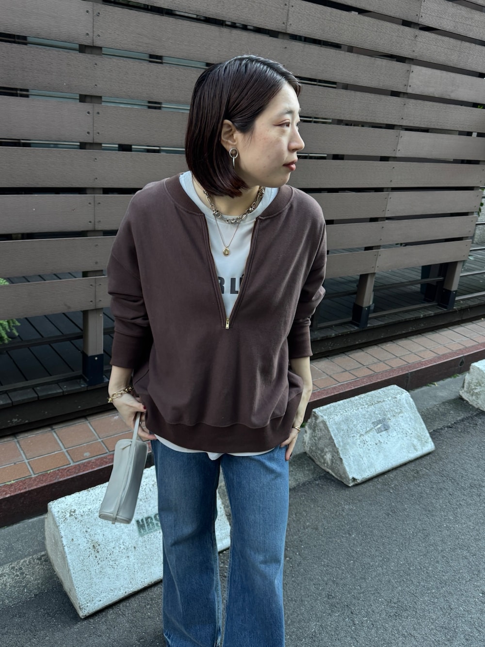 ブラウン系のスウェット、グレー系のシャツ/ブラウス、ブルー系のデニムパンツを着用したレディースの冬コーディネートの8枚目の写真