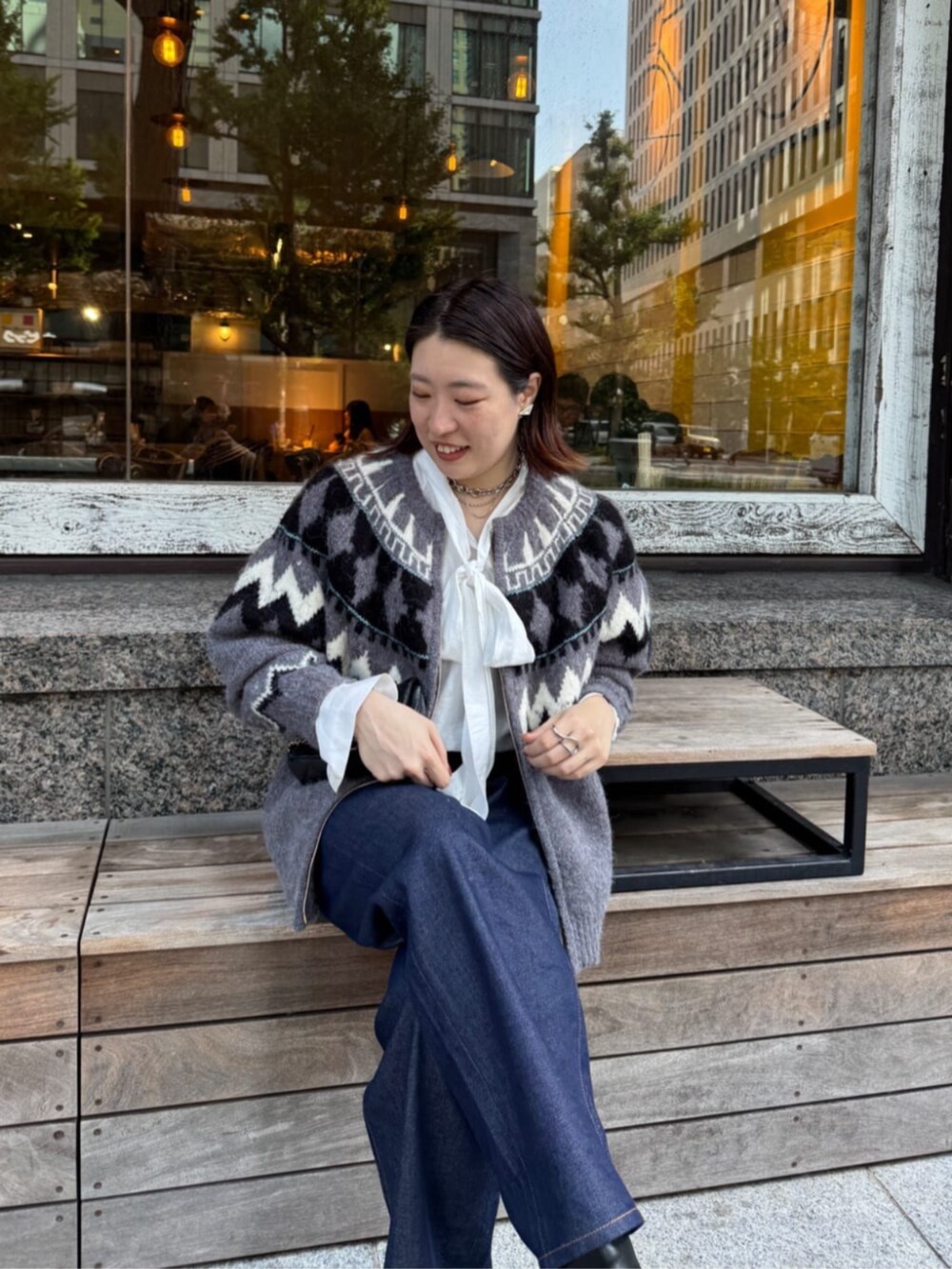 ブラック系のショルダーバッグ、ブルー系のデニムパンツ、ホワイト系のシャツ/ブラウスを着用したレディースの秋コーディネートの7枚目の写真