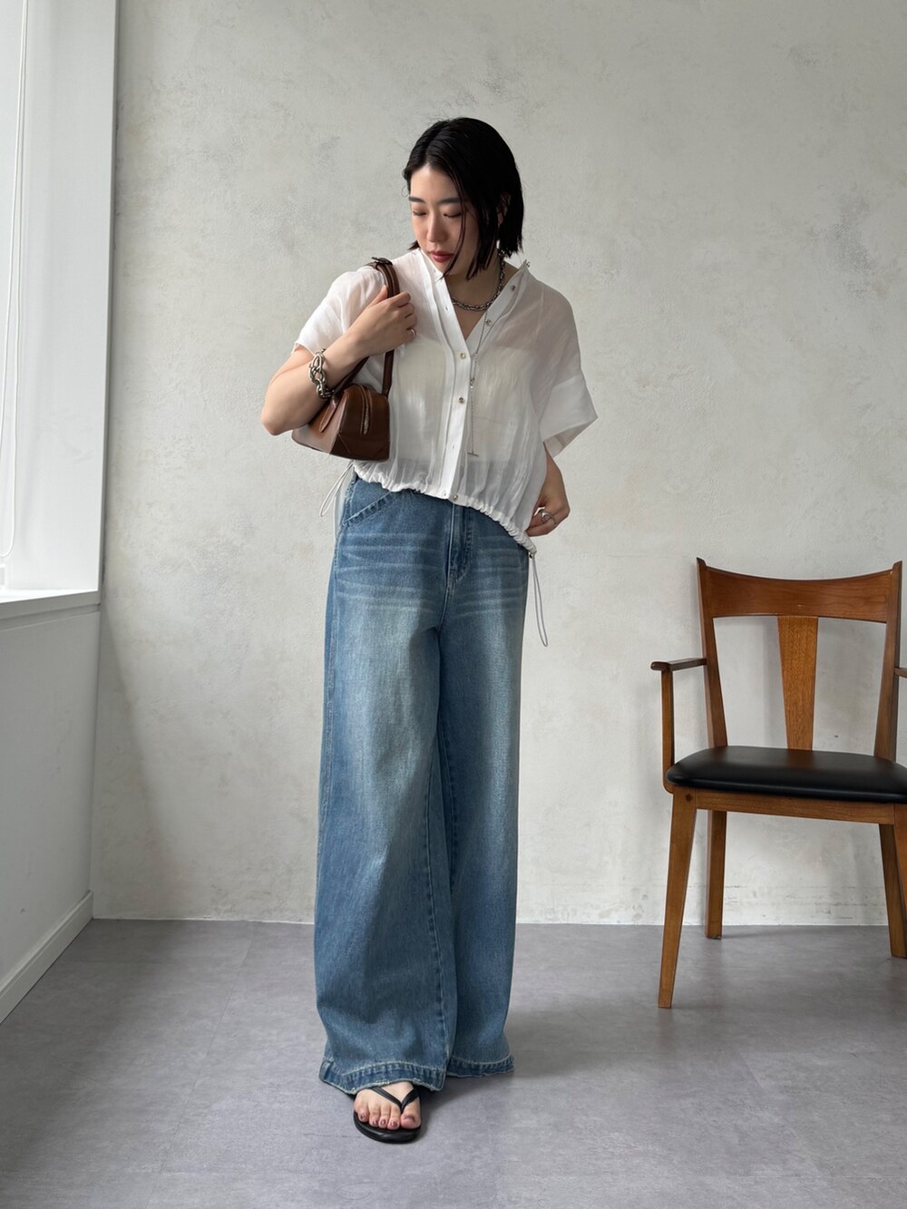 ブルー系のデニムパンツ、ホワイト系のシャツ/ブラウスを着用したレディースの夏コーディネートの3枚目の写真