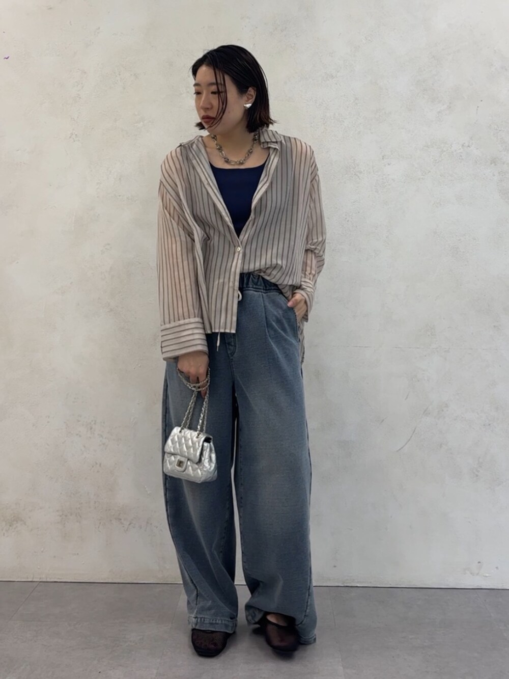ブルー系のその他パンツ、ホワイト系のシャツ/ブラウス、シルバー系のショルダーバッグを着用したレディースの夏コーディネートの4枚目の写真
