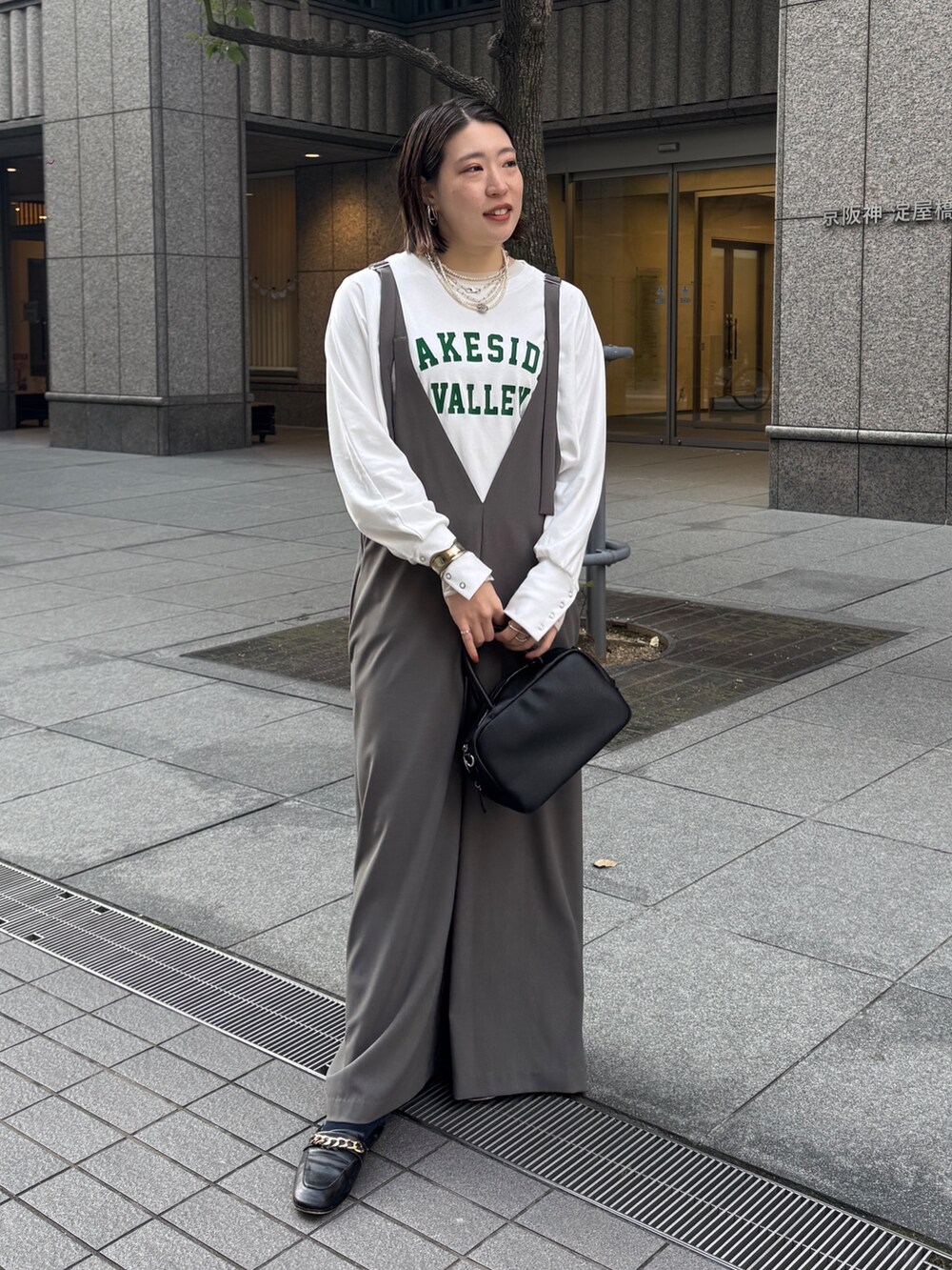 グレー系のつなぎ/オールインワン、ホワイト系のTシャツ/カットソー、シルバー系のネックレスを着用したレディースの冬コーディネートの2枚目の写真