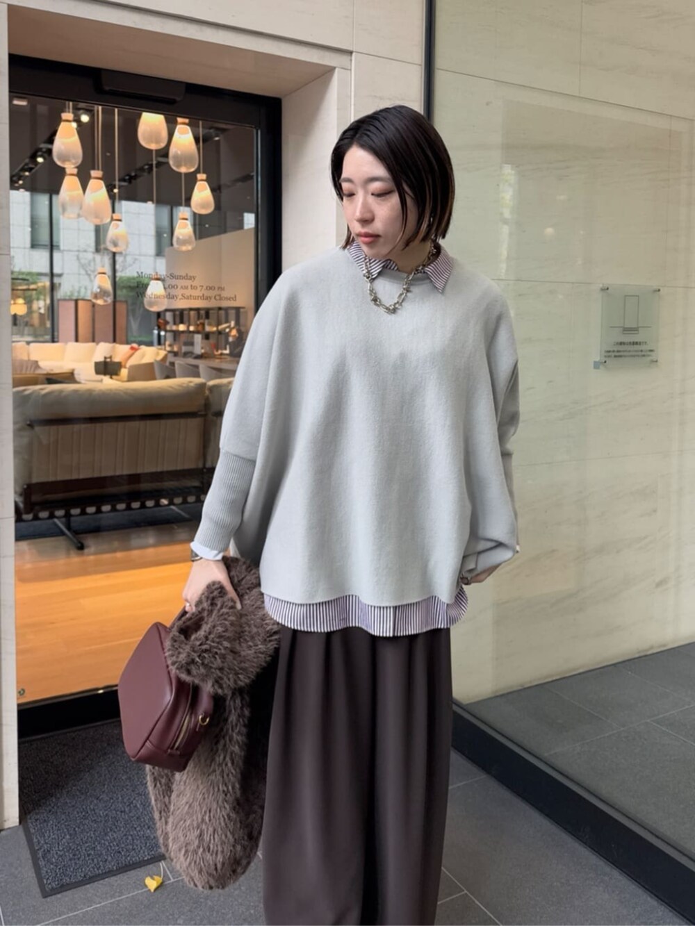 ブラウン系のスラックス、レッド系のシャツ/ブラウス、ブラウン系のショルダーバッグを着用したレディースの冬コーディネートの5枚目の写真