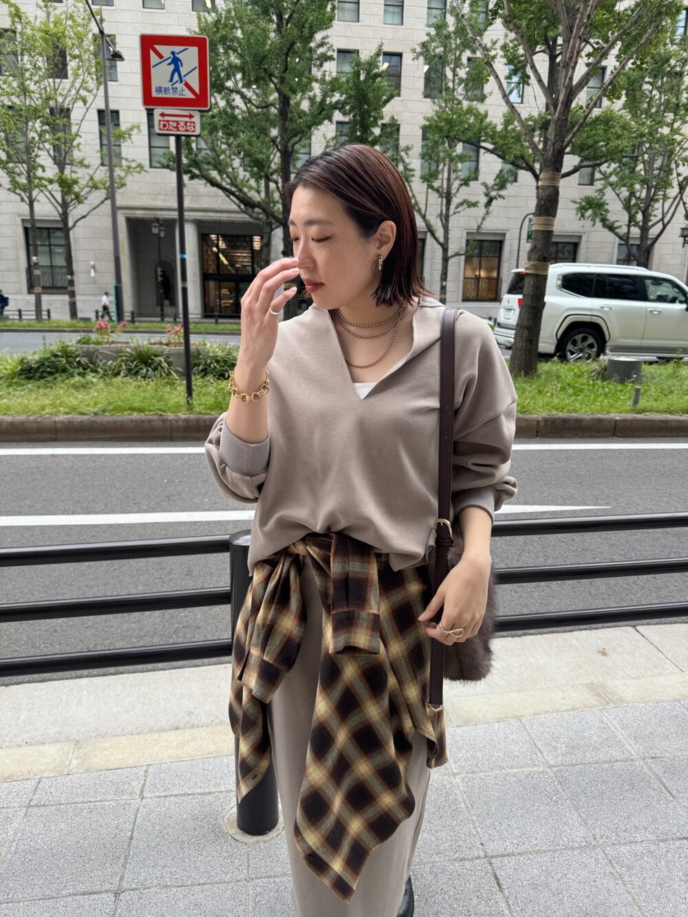 ベージュ系のTシャツ/カットソー、ベージュ系のスカート、ブラウン系のショルダーバッグを着用したレディースの秋コーディネートの8枚目の写真