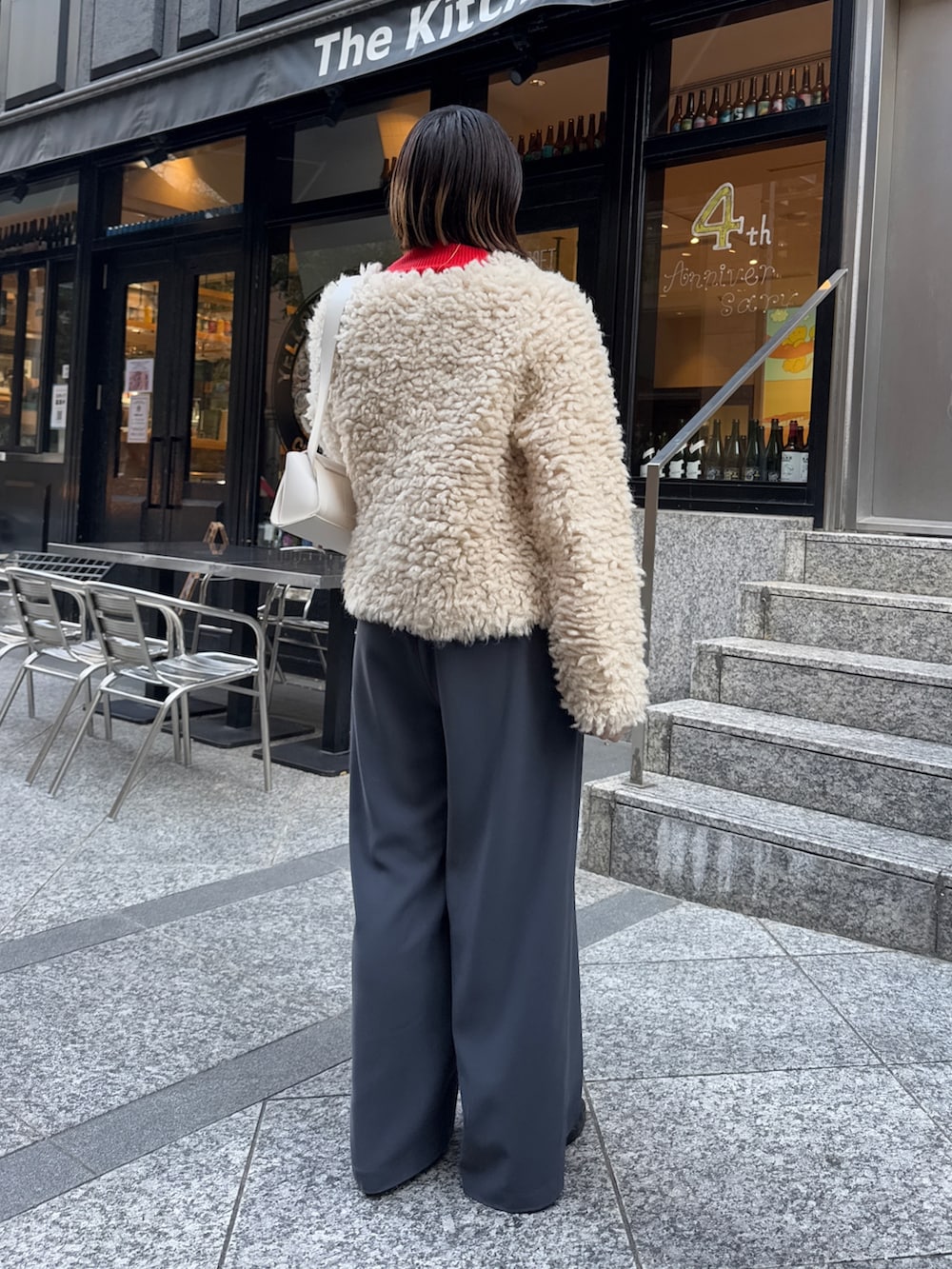 グレー系のスラックス、ホワイト系のショルダーバッグ、ベージュ系のカーディガン/ボレロを着用したレディースの冬コーディネートの4枚目の写真