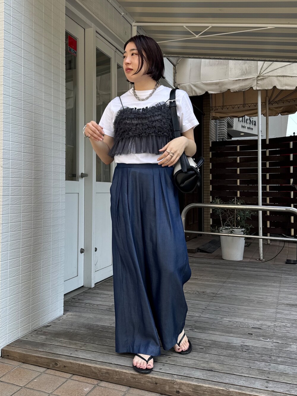 ブルー系のデニムパンツ、ホワイト系のTシャツ/カットソー、グレー系のキャミソールを着用したレディースの夏コーディネートの6枚目の写真