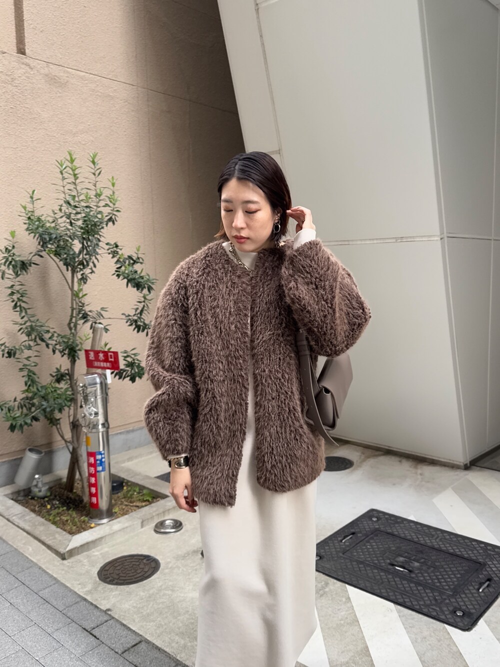 ベージュ系のワンピース、ブラウン系のその他アウター、ブラウン系のブーツを着用したレディースの冬コーディネートの4枚目の写真