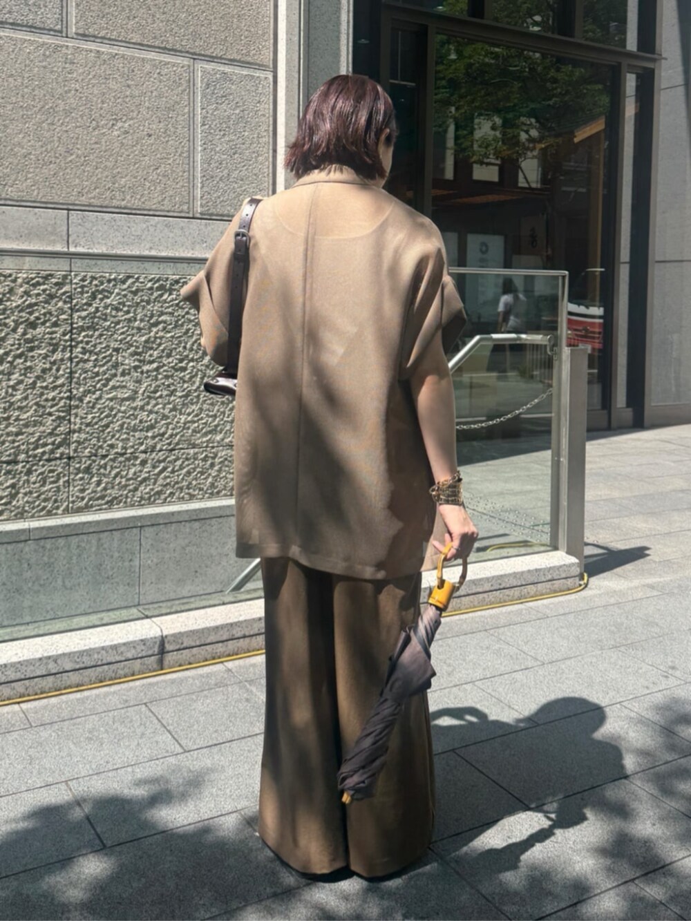 ホワイト系のタンクトップ、ブラウン系のテーラードジャケット、ベージュ系のワンピースを着用したレディースの夏コーディネートの3枚目の写真