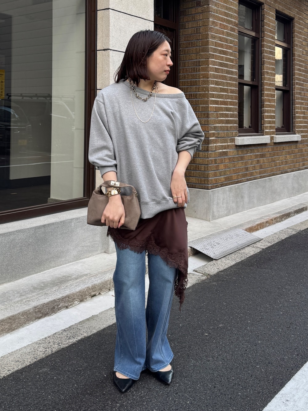 グレー系のTシャツ/カットソー、ブラウン系のキャミソール、ブルー系のデニムパンツを着用したレディースの冬コーディネートの5枚目の写真