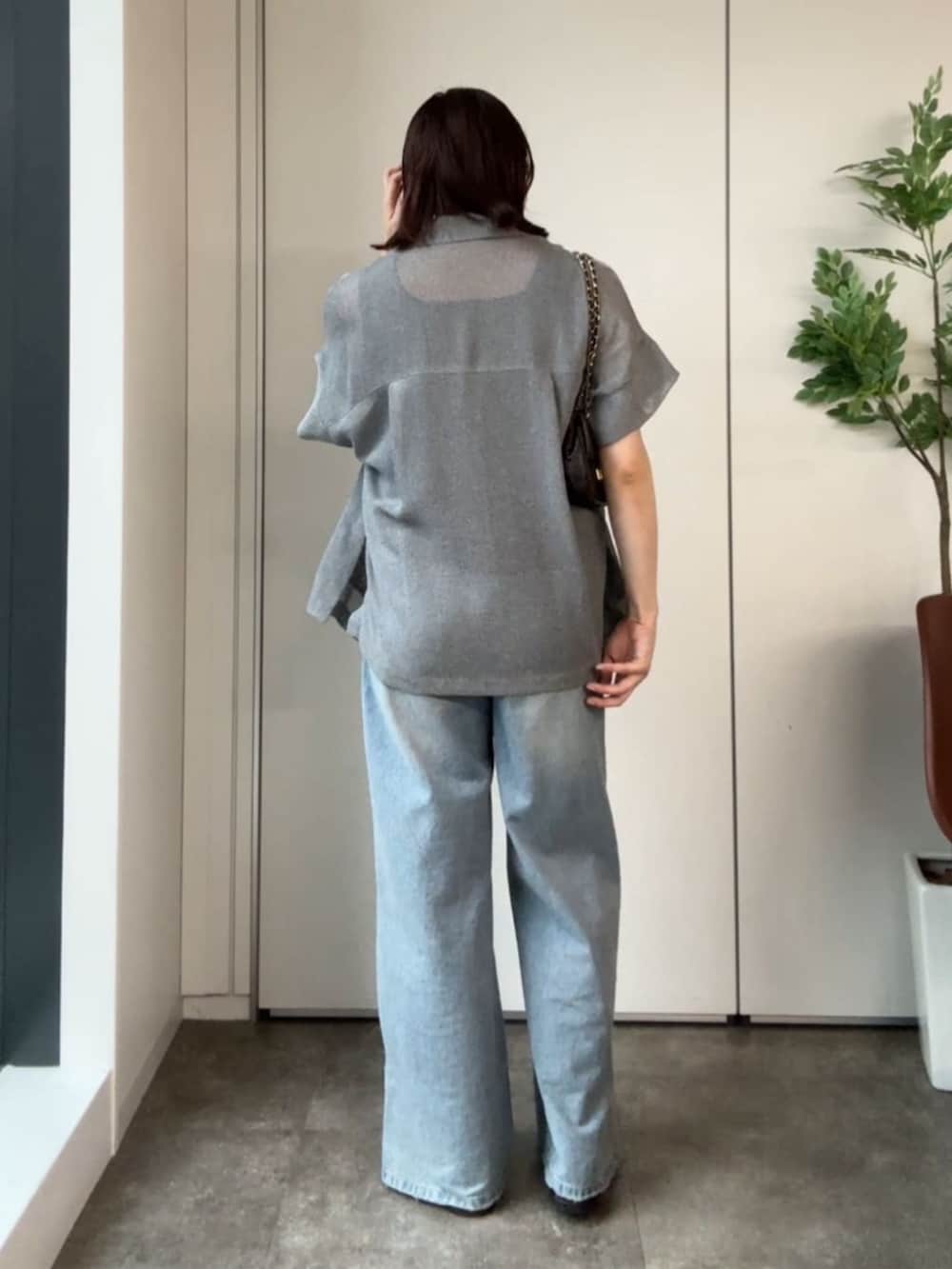 ブルー系のタンクトップ、ブルー系のデニムパンツ、ブラウン系のサンダルを着用したレディースの夏コーディネートの4枚目の写真