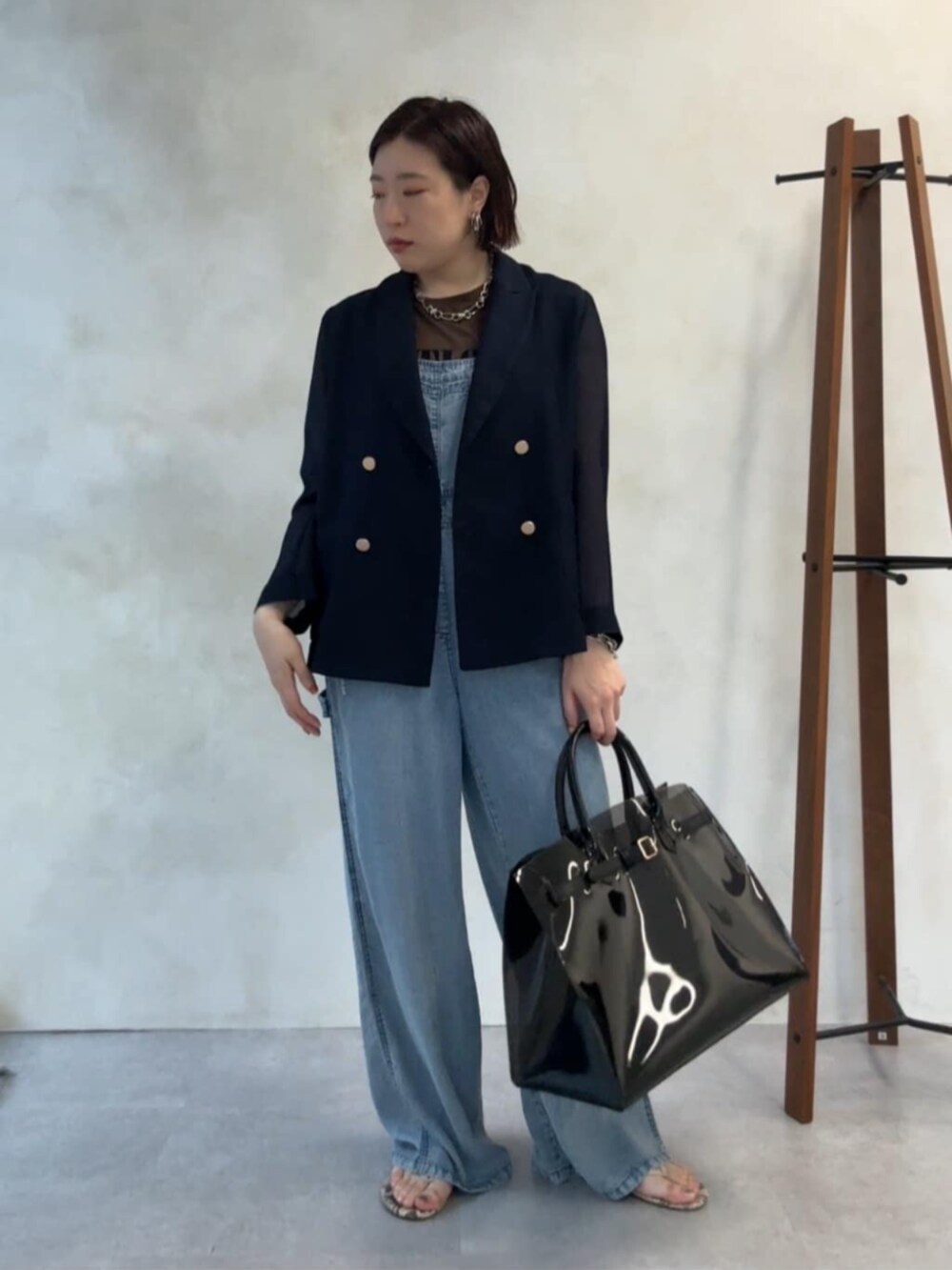 ブルー系のテーラードジャケット、ブラック系のショルダーバッグ、ブルー系のつなぎ/オールインワンを着用したレディースの夏コーディネートの6枚目の写真