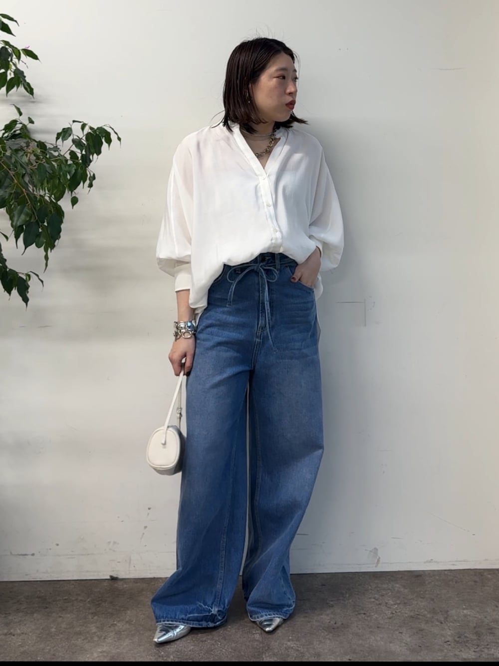 ホワイト系のシャツ/ブラウス、ブルー系のデニムパンツを着用したレディースの冬コーディネートの3枚目の写真