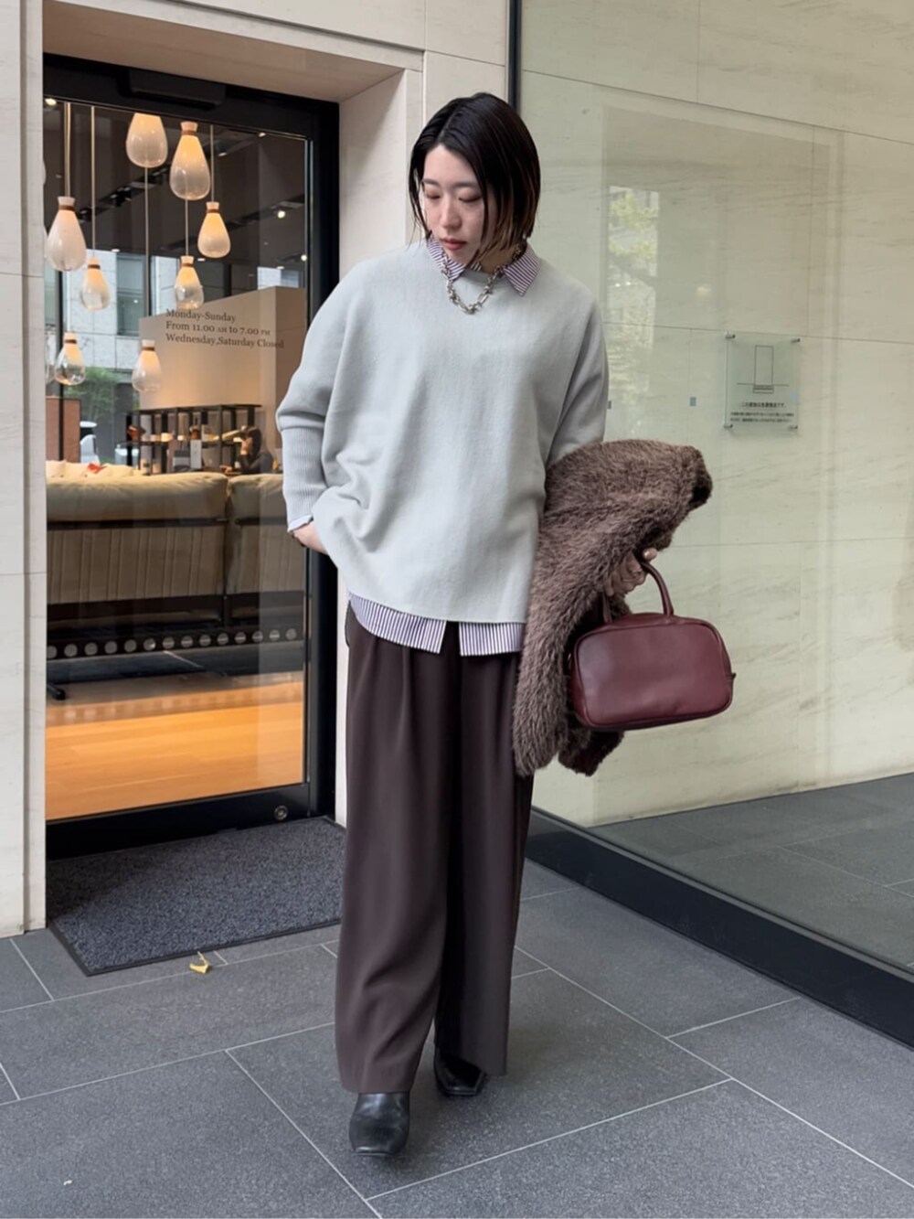 ブラウン系のスラックス、レッド系のシャツ/ブラウス、ブラウン系のショルダーバッグを着用したレディースの冬コーディネートの7枚目の写真