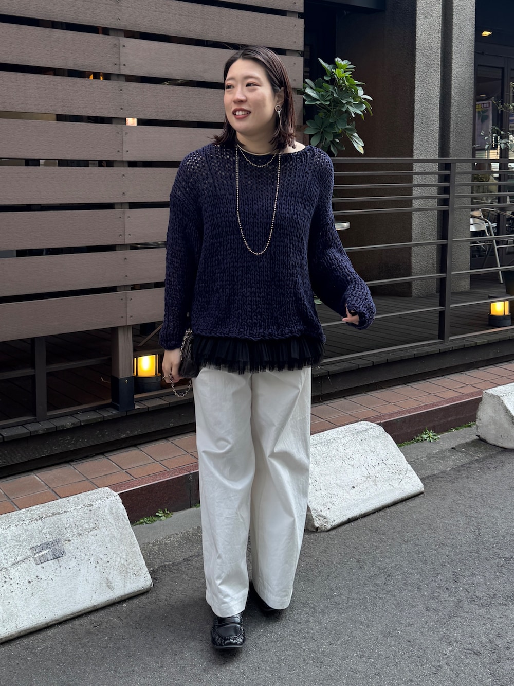 ブルー系のニット/セーター、ブラック系のシャツ/ブラウス、ホワイト系のその他パンツを着用したレディースの春コーディネートの3枚目の写真