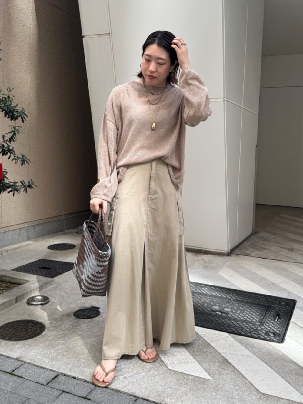 ベージュ系のスカート、ゴールド系のネックレスを着用したレディースの春コーディネートの6枚目の写真