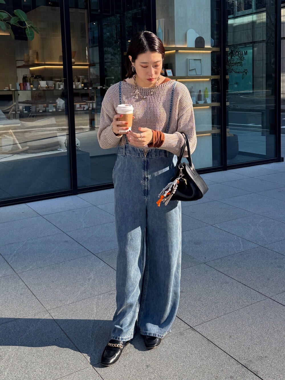 ベージュ系のニット/セーター、ブルー系のデニムパンツ、ブラウン系のTシャツ/カットソーを着用したレディースの冬コーディネートの3枚目の写真