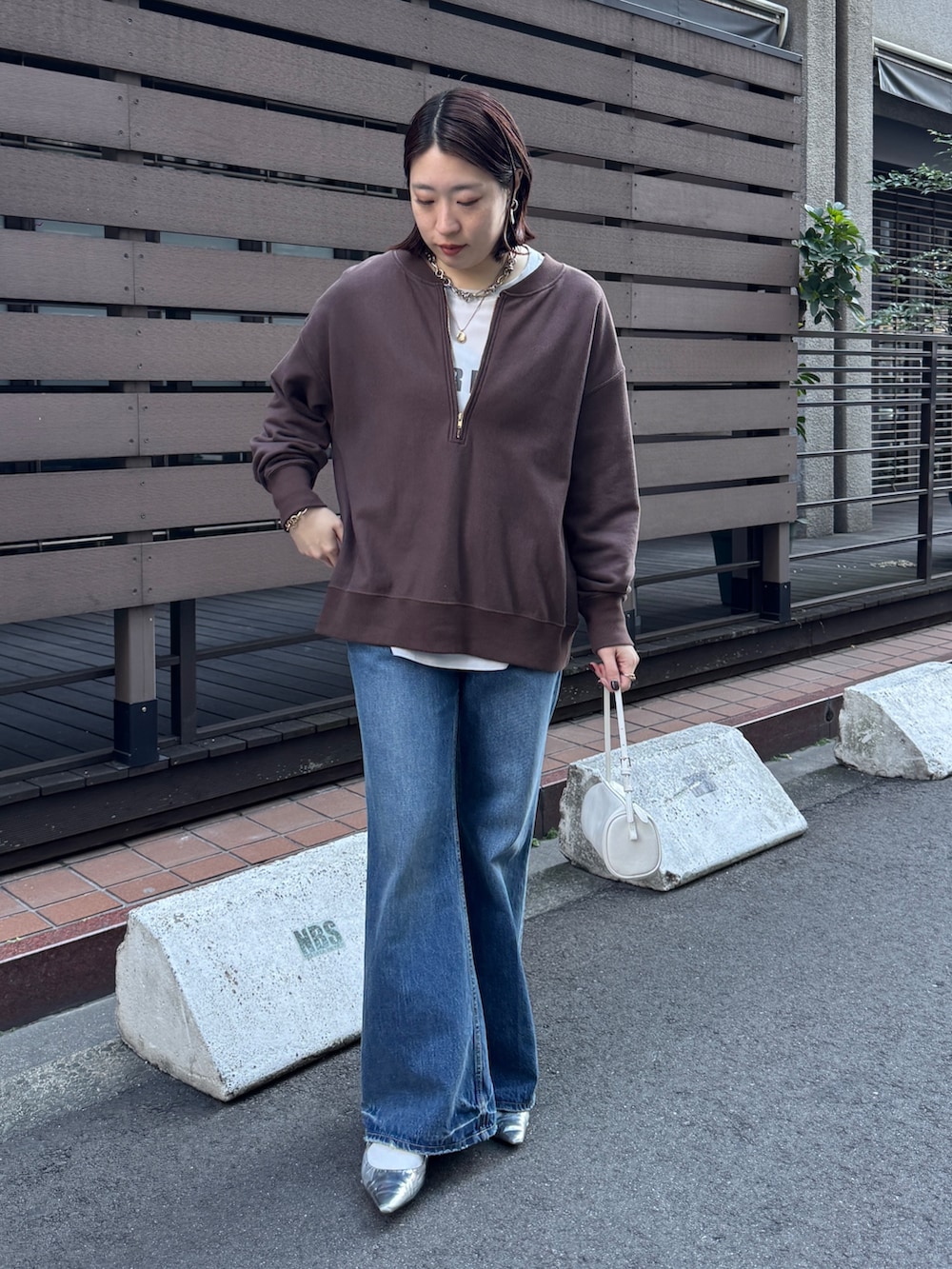 ブラウン系のスウェット、グレー系のシャツ/ブラウス、ブルー系のデニムパンツを着用したレディースの冬コーディネートの7枚目の写真