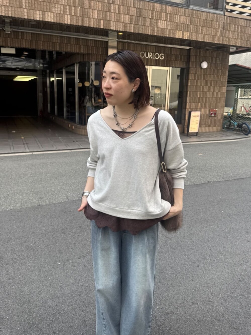 ブルー系のデニムパンツ、ブラウン系のパンプス、ブラウン系のシャツ/ブラウスを着用したレディースの夏コーディネートの2枚目の写真