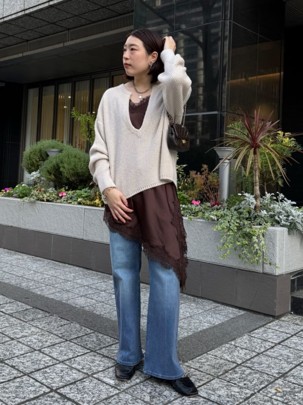 ブラウン系のキャミソール、ブルー系のデニムパンツ、ホワイト系のニット/セーターを着用したレディースの冬コーディネートの9枚目の写真