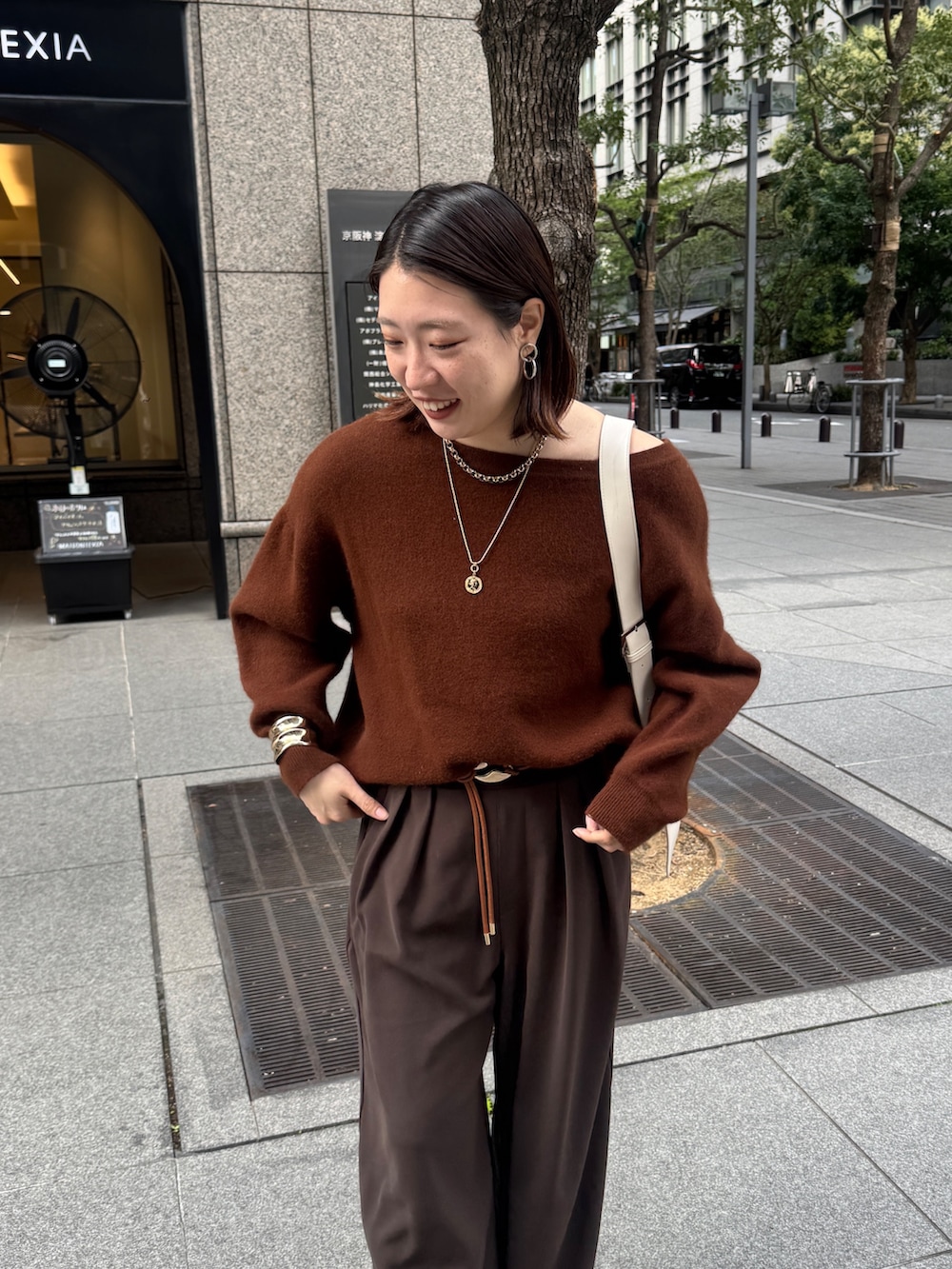 ブラウン系のニット/セーター、ブラウン系のスラックス、ブラウン系のベルトを着用したレディースの秋コーディネートの9枚目の写真