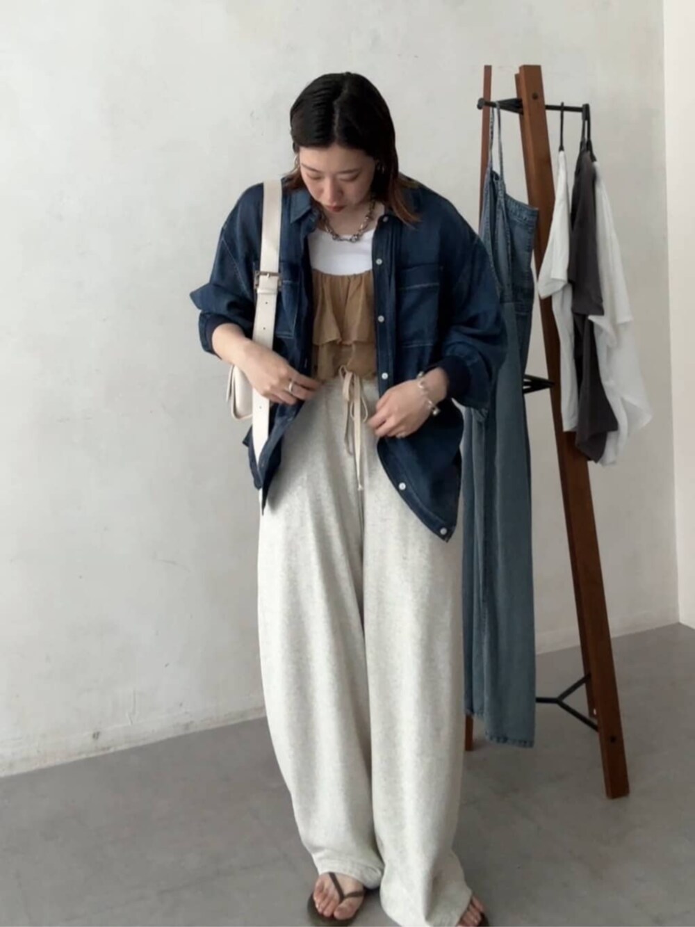 ホワイト系のショルダーバッグ、ベージュ系のその他パンツ、ブルー系のシャツ/ブラウスを着用したレディースの春コーディネートの4枚目の写真