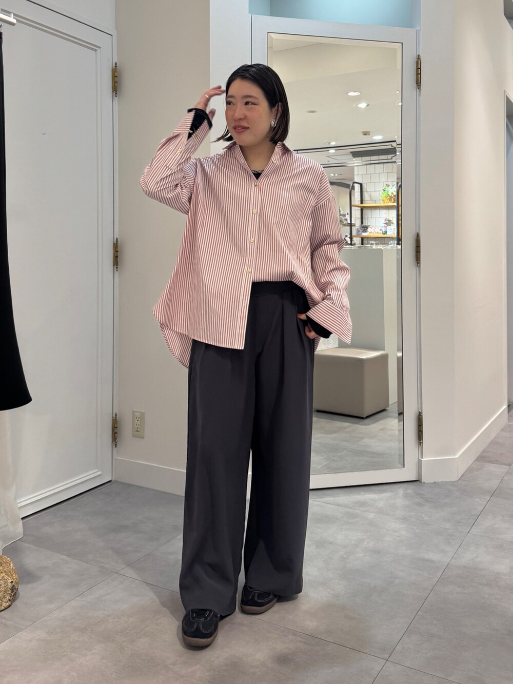 ブラウン系のスラックス、レッド系のシャツ/ブラウス、ブルー系のTシャツ/カットソーを着用したレディースの春コーディネートの3枚目の写真