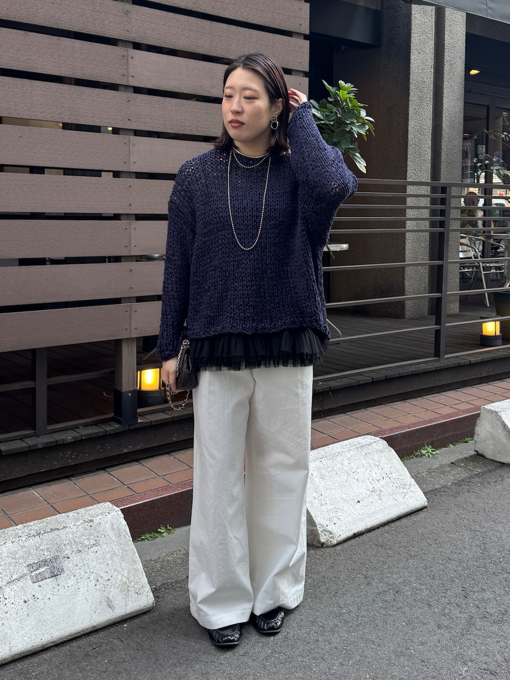 ブルー系のニット/セーター、ブラック系のシャツ/ブラウス、ホワイト系のその他パンツを着用したレディースの春コーディネートの6枚目の写真