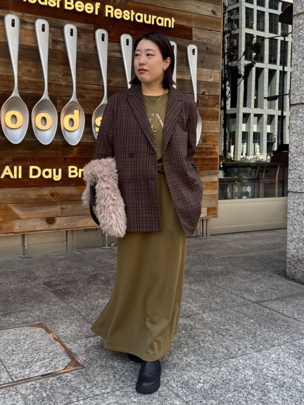 グリーン系のTシャツ/カットソー、グリーン系のスカート、ブラウン系のテーラードジャケットを着用したレディースの夏コーディネートの2枚目の写真