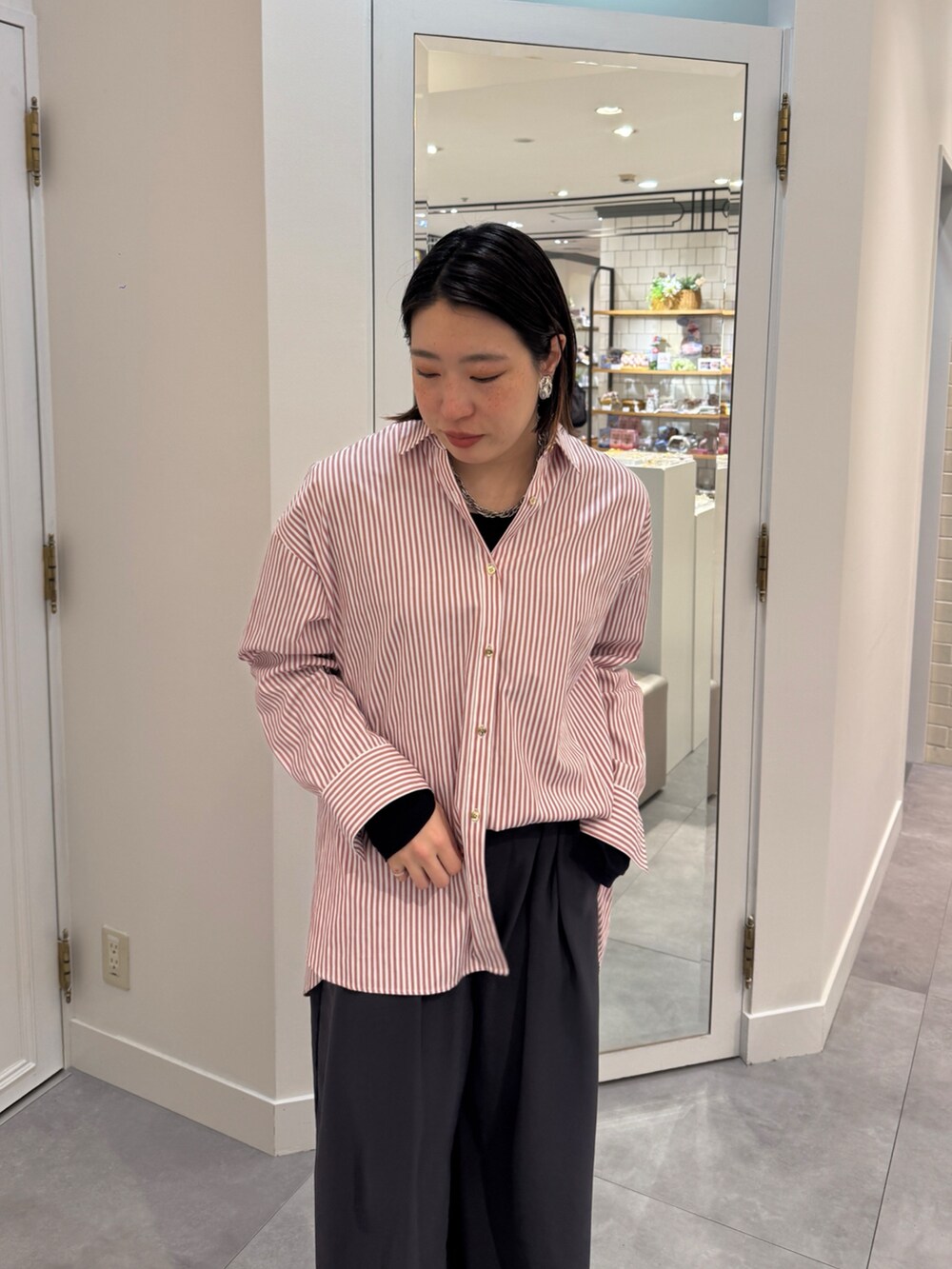 ブラウン系のスラックス、レッド系のシャツ/ブラウス、ブルー系のTシャツ/カットソーを着用したレディースの春コーディネートの8枚目の写真