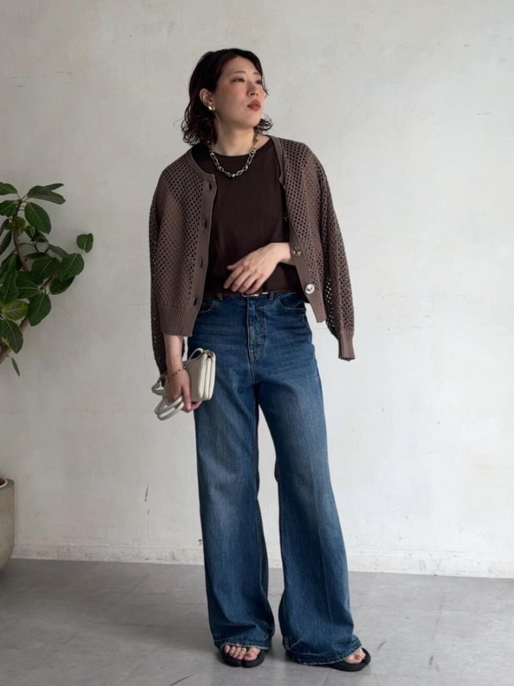 ブラウン系のTシャツ/カットソー、ブルー系のデニムパンツ、ベージュ系のカーディガン/ボレロを着用したレディースの夏コーディネートの4枚目の写真