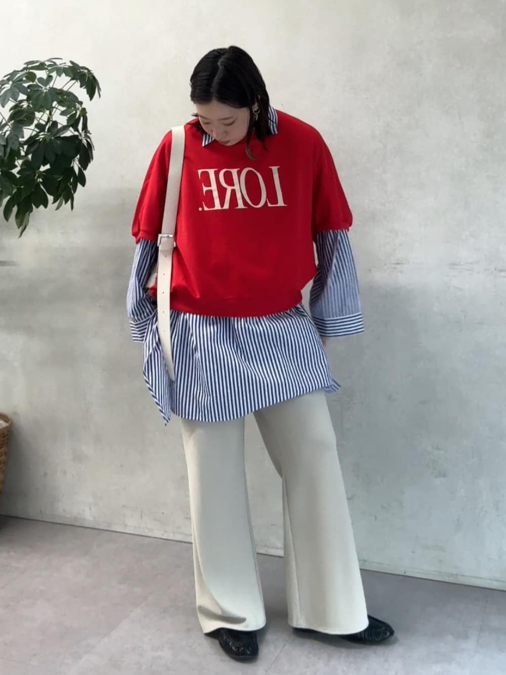 ブルー系のシャツ/ブラウス、レッド系のTシャツ/カットソー、ベージュ系のその他パンツを着用したレディースの春コーディネートの4枚目の写真