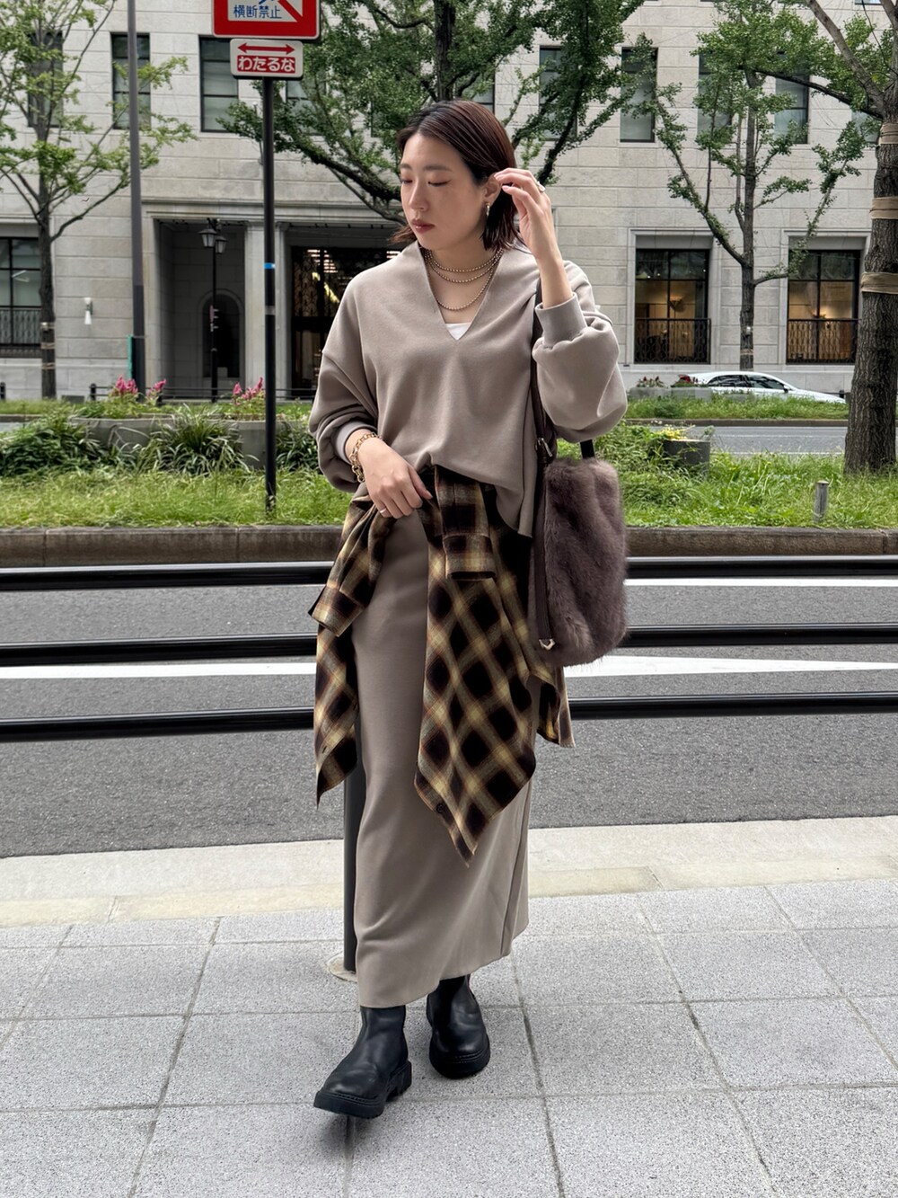 ベージュ系のTシャツ/カットソー、ベージュ系のスカート、ブラウン系のショルダーバッグを着用したレディースの秋コーディネートの5枚目の写真