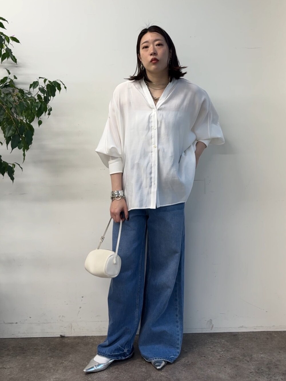 ホワイト系のシャツ/ブラウス、ブルー系のデニムパンツを着用したレディースの冬コーディネートの6枚目の写真