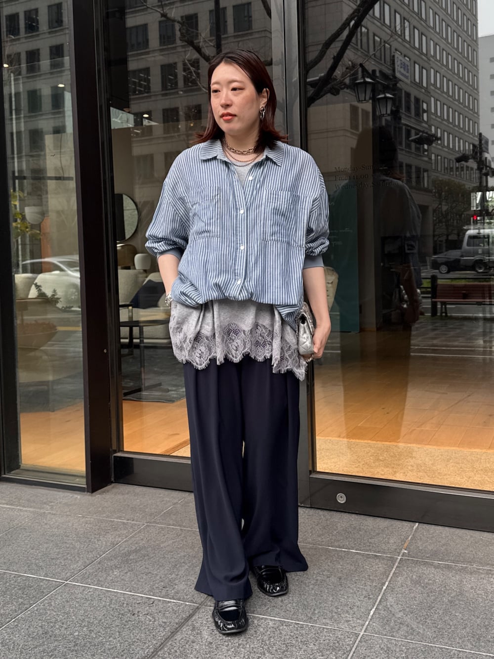 グレー系のTシャツ/カットソー、ブルー系のシャツ/ブラウス、ブルー系のスラックスを着用したレディースの春コーディネートの4枚目の写真