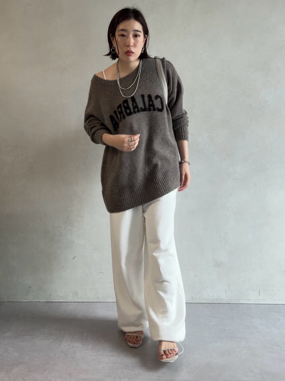 ベージュ系のニット/セーター、ホワイト系のスウェットパンツ、グレー系のショルダーバッグを着用したレディースの秋コーディネートの4枚目の写真